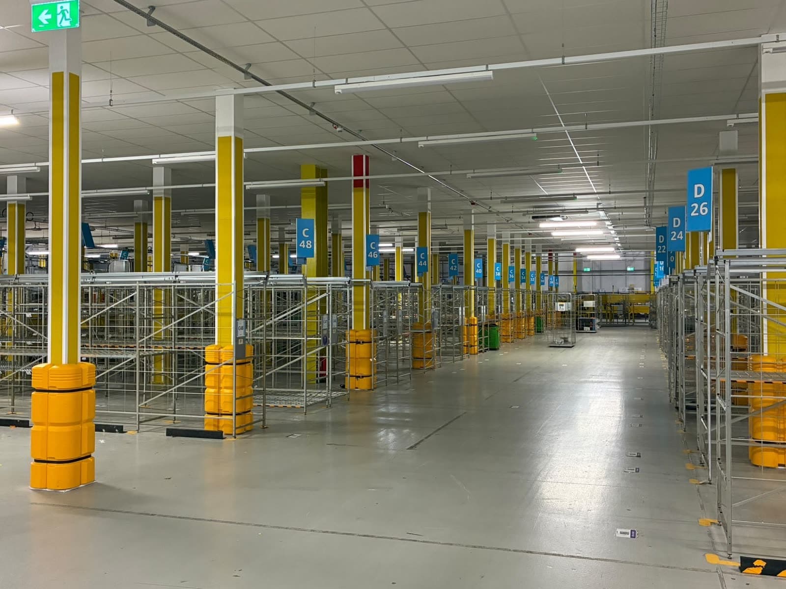 Rows of columns under the mezzanine, painted yellow with white bands at the top, one with a red band