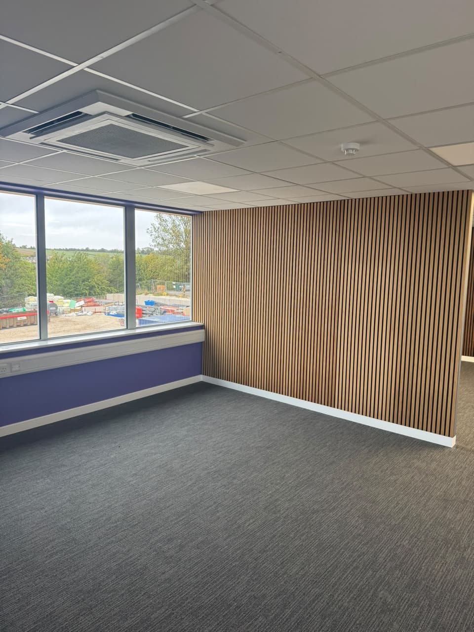 Slatted wall panelling meets purple decoration and white skirting